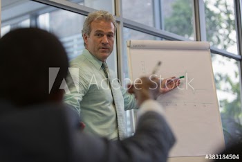 Businessman at flipchart leading conference room meeting