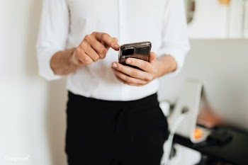 Businessman checking his social media account and messages on a phone | Free  photo - 2353141