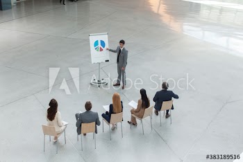 Businessman explaining pie chart on flipchart in meeting