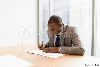 Businessman filling out paperwork in conference room