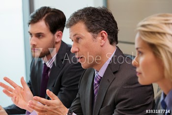 Businessman gesturing and explaining in conference room meeting