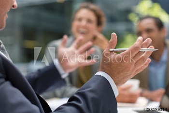 Businessman gesturing in meeting with colleagues