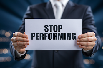 Businessman Holding 'Stop Performing' Sign