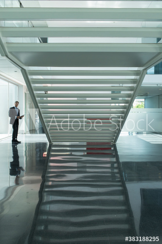 Businessman in modern office lobby with staircase