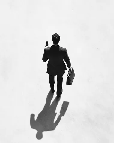 Businessman in Suit and Tie Walking with Briefcase in Urban Setting