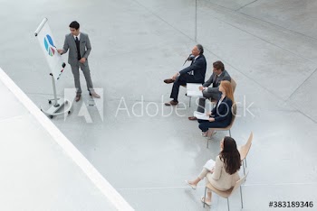 Businessman leading meeting at flipchart with pie chart