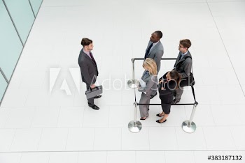 Businessman looking at business people trapped in square stanchions