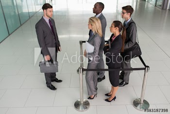 Businessman looking at colleagues trapped in square stanchions