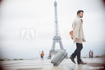 Businessman pulling suitcase, Eiffel Tower, Paris, France