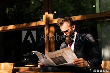 Businessman reading newspaper at coffee shop