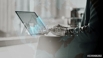 Businessman reading stock markets on a laptop