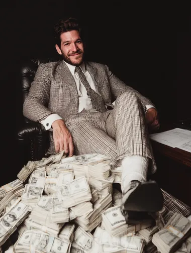 Businessman Sitting on Piles of Cash Businessman Sitting on Piles of Cash