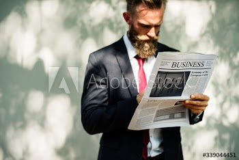 Businessman standing and reading newspaper