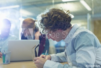 Businessman taking notes in conference room meeting