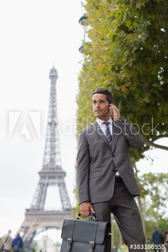 Businessman talking on mobile phone below Eiffel Tower, Paris, France