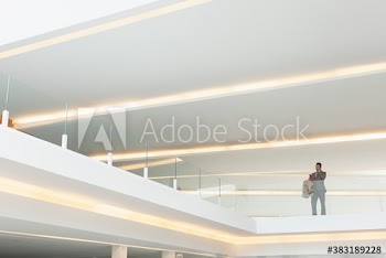 Businessman talking on mobile phone on modern balcony
