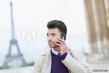 Businessman talking on smart phone at Eiffel Tower, Paris, France