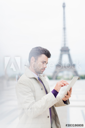Businessman using digital tablet near Eiffel Tower, Paris, France