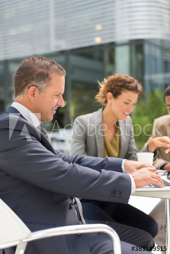 Businessman using laptop at outdoor cafe