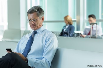 Businessman using smart phone in airport