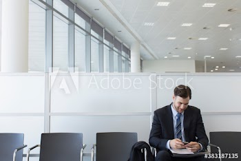 Businessman using smart phone in office lobby