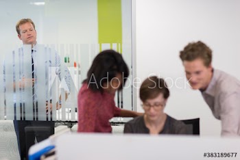 Businessman watching colleagues at computer in office