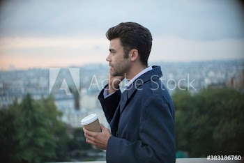 Businessman with coffee talking on smart phone, Montmartre, Paris