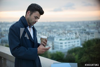 Businessman with coffee using smart phone, Montmartre, Paris, France