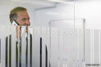 Businessman with smart phone in office