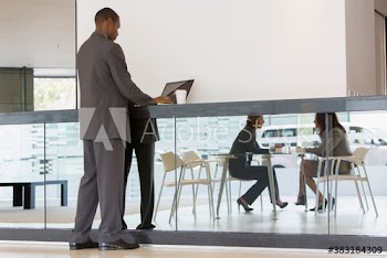 Businessman working at laptop in cafeteria