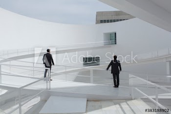 Businessmen on sunny modern courtyard ramp