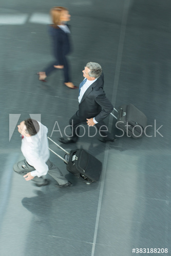 Businessmen running with suitcases in airport