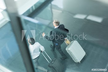 Businessmen running with suitcases in airport