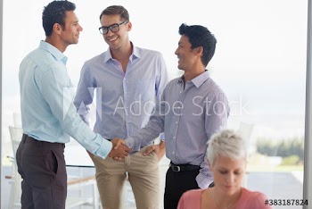 Businessmen shaking hands in office