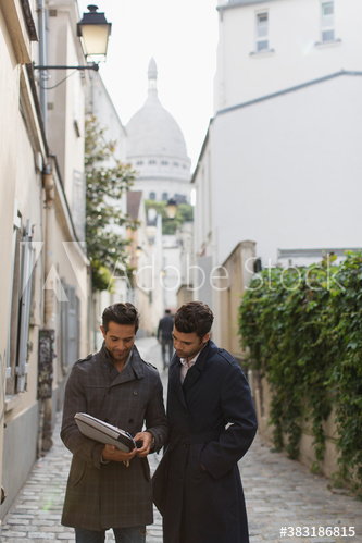 Businessmen talking on cobblestone street, Montmartre, Paris, France