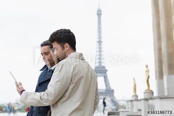 Businessmen using digital tablet, Eiffel Tower, Paris, France