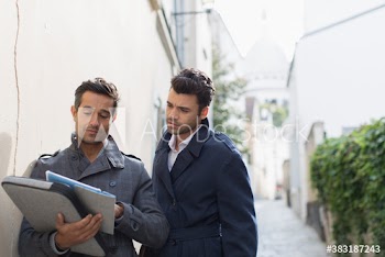 Businessmen using digital tablet on street