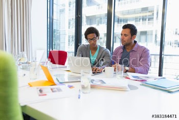 Businessmen using laptop in conference room meeting