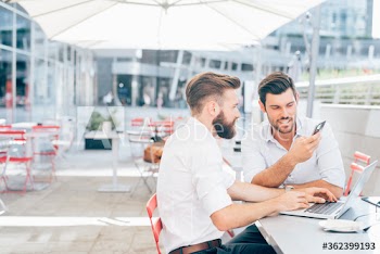 Businessmen using technology while sitting in cafe