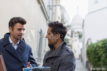 Businessmen with digital tablet talking outdoors