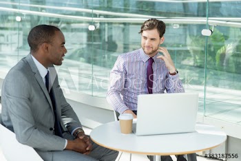 Businessmen with laptop meeting at cafe