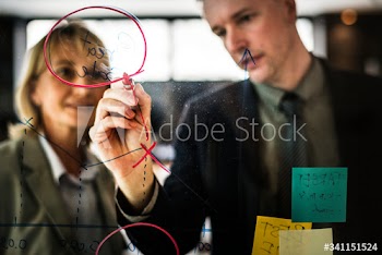 Businesspeople planning on a glass wall