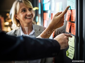 Businesspeople planning tasks with sticky notes