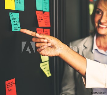 Businesspeople planning tasks with sticky notes