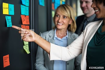 Businesspeople planning tasks with sticky notes