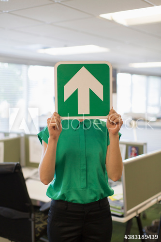 Businesswoman covering face with arrow sign