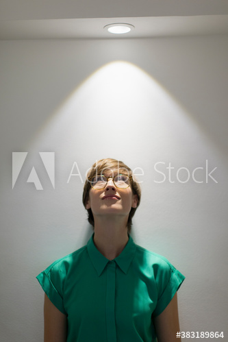 Businesswoman looking up at light
