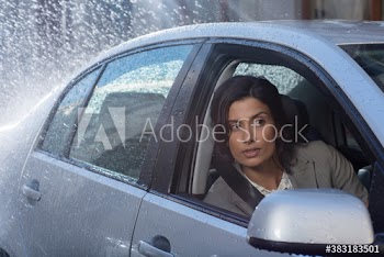 Businesswoman peering out car window in rain