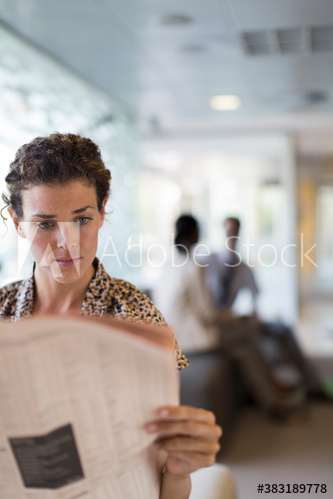 Businesswoman reading newspaper
