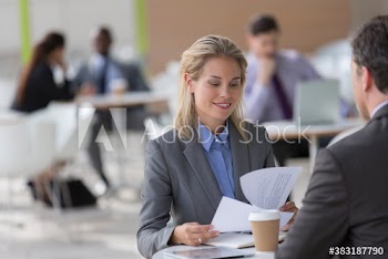 Businesswoman reviewing paperwork in cafe